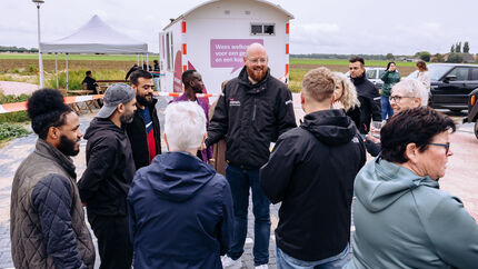 Consulent Sociaal Beheer Wesley Rotteveel deelt patat uit aan een groepje bewoners en omwonenden van de Nautalaan.